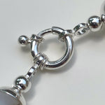 Close-up of a silver bracelet with large beads on a white background