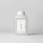 Bottle of organic denim wash with oud perfume by Tangent GC on a light gray background