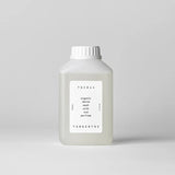 Bottle of organic denim wash with oud perfume by Tangent GC on a light gray background
