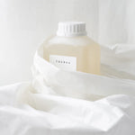 White bottle with a label on a white fabric background