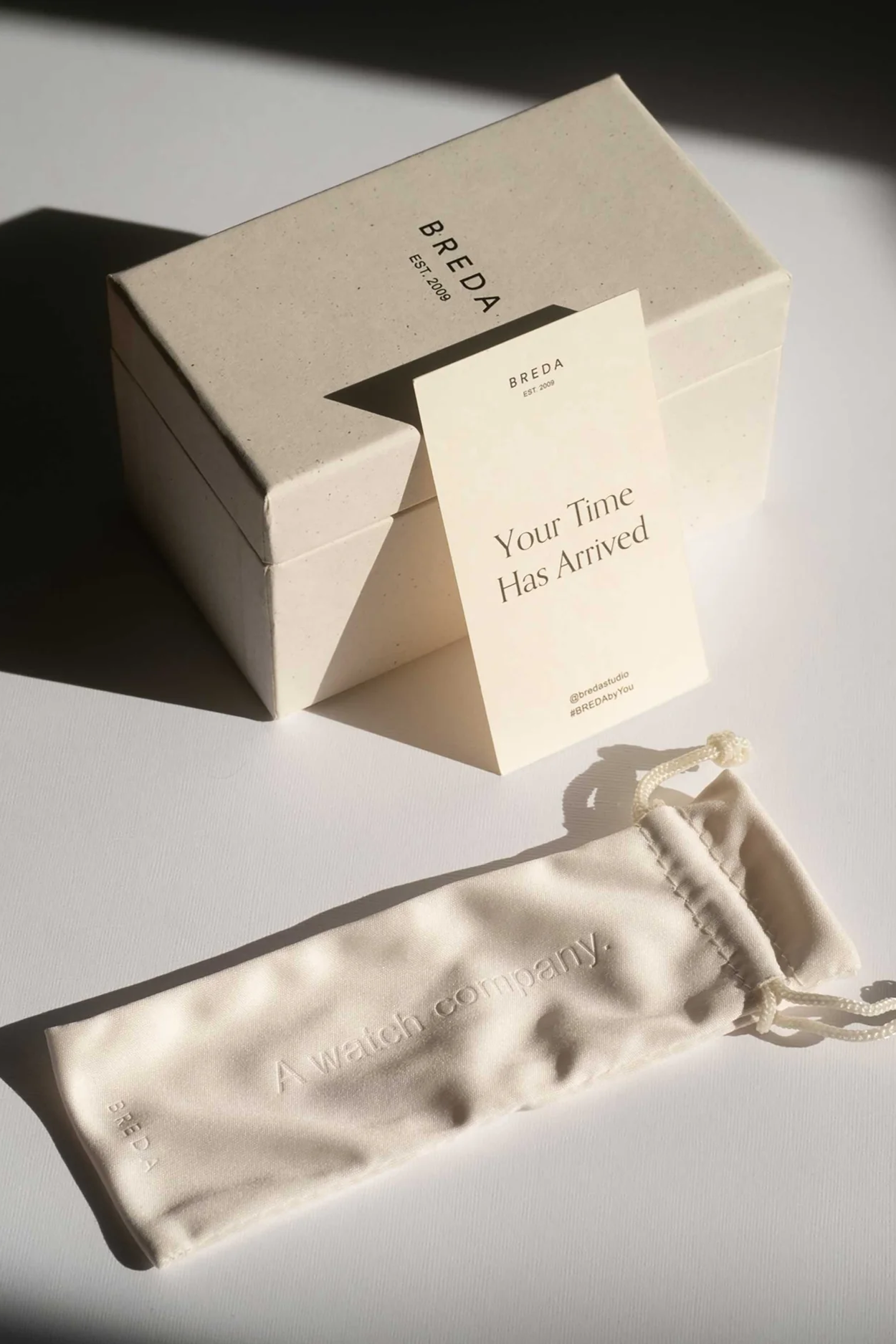 Breda box with a card and a watch pouch on a light surface