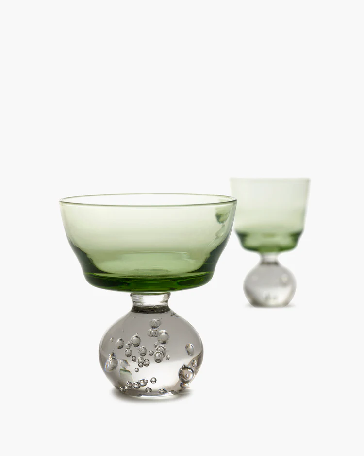 Two green glass goblets on a white background