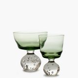 Two green glass goblets with bubble designs on a white background