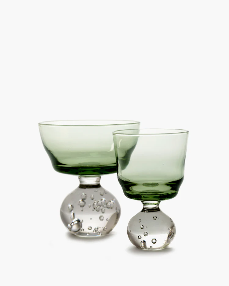 Two green glass goblets with bubble designs on a white background