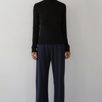 image of model in black turtleneck and blue pants from a distance