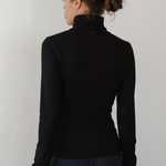image of back of black turtleneck on model