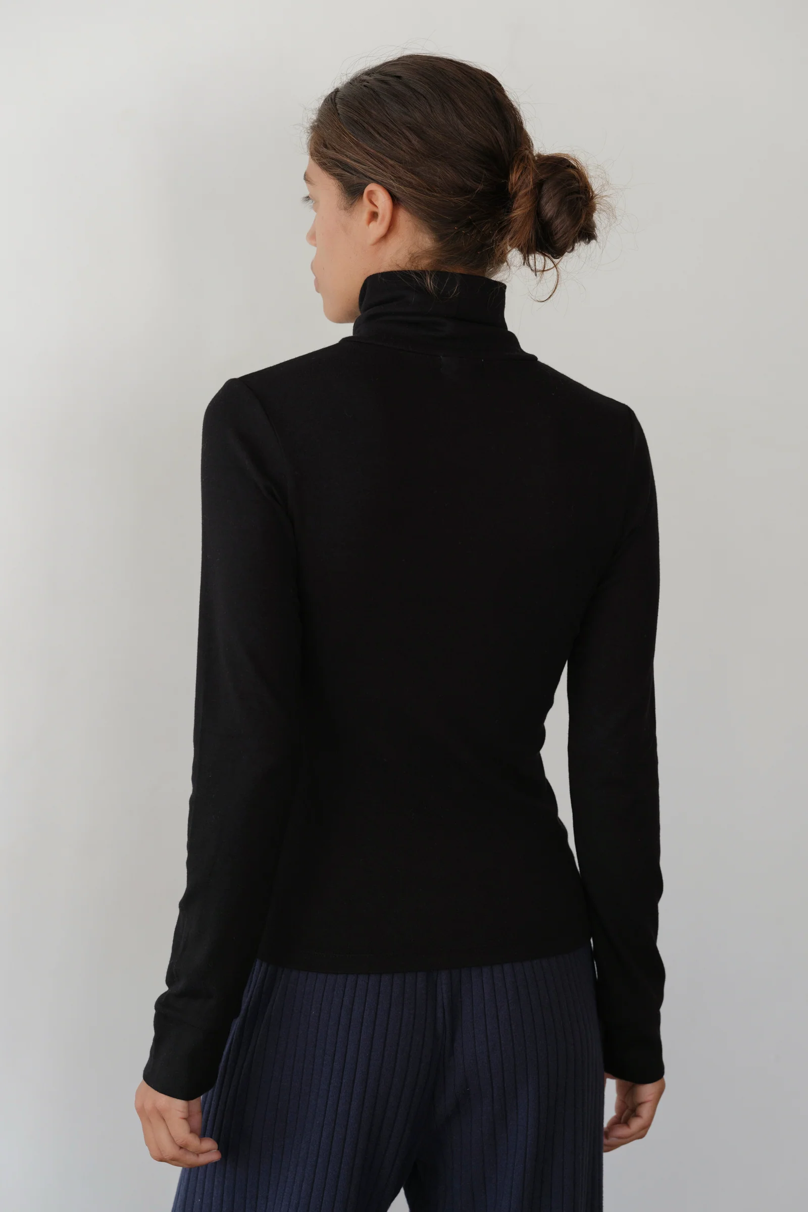 image of back of black turtleneck on model