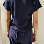 Person wearing a navy blue outfit against a white background