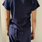 Person wearing a navy blue outfit against a white background