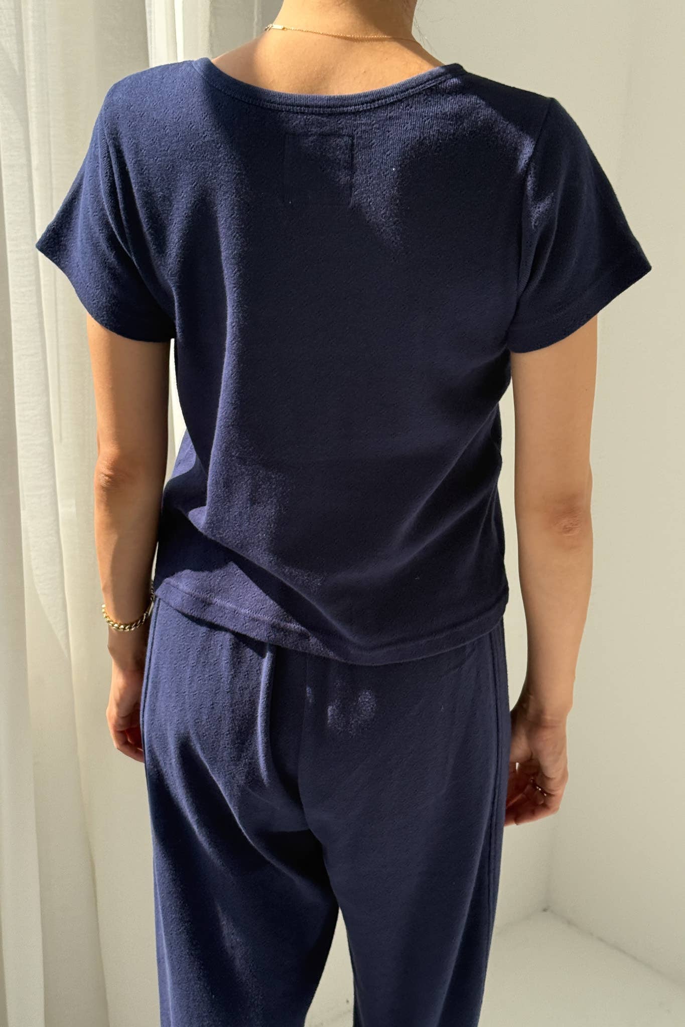 Person wearing a navy blue outfit against a white background