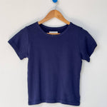 Navy blue t-shirt on a wooden hanger against a white background