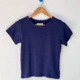 Navy blue t-shirt on a wooden hanger against a white background