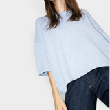 JONES + CO oversized heathered blue crew-neck sweater with short sleeves and dropped shoulders worn by a model