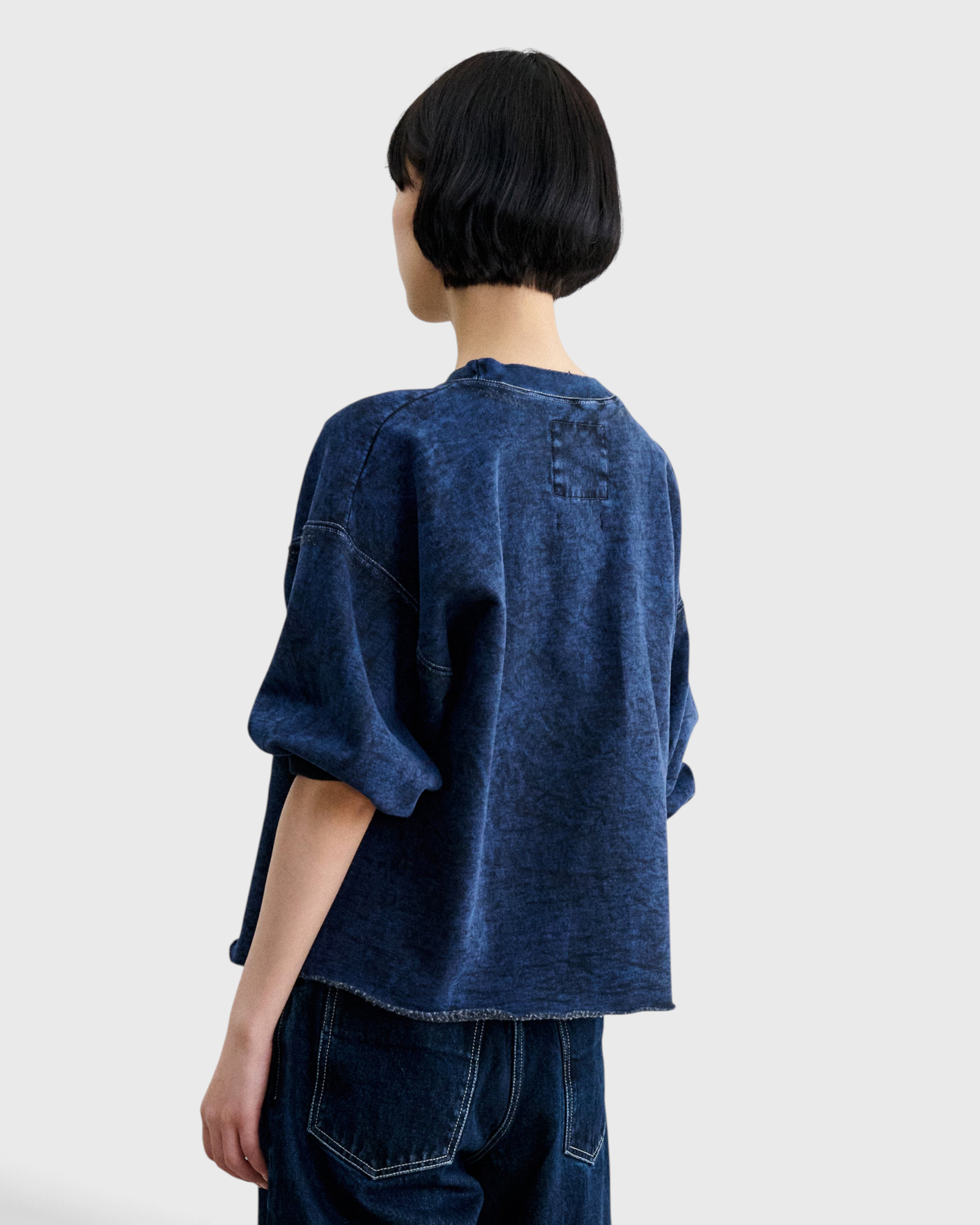 JONES + CO Rachel Comey Fond sweatshirt in acid wash indigo, back view showing raw-edge hem and label patch.