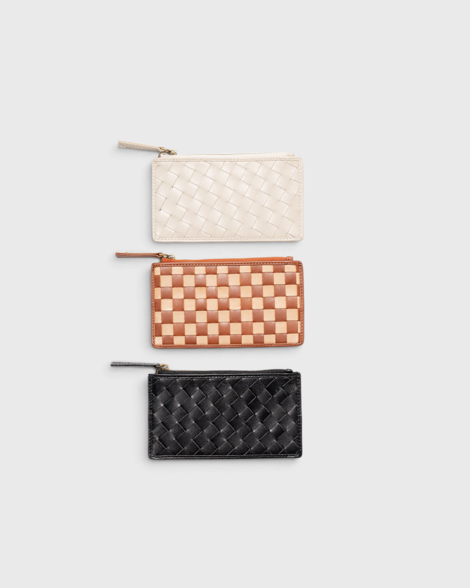JONES + CO Odin card cases in white, tan, and black woven leather with zip closures and minimalist slim design.