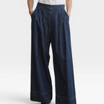 JONES + CO Coxsone dark indigo denim trousers, front view with hands in side slip pockets.