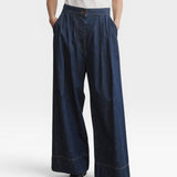 JONES + CO Coxsone dark indigo denim trousers, front view with hands in side slip pockets.