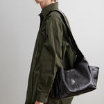 RACHEL COMEY Tool Bag in black leather, side view showing extended exterior pocket.