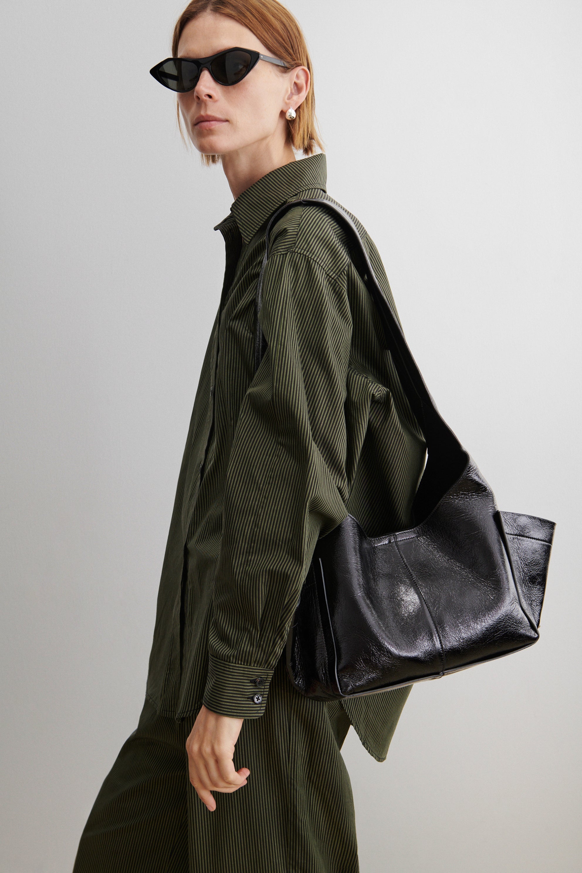 RACHEL COMEY Tool Bag in black leather, side view showing extended exterior pocket.