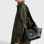 RACHEL COMEY Tool Bag in black leather, side view showing extended exterior pocket.