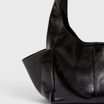 Model carrying the RACHEL COMEY Tool Bag in black leather across the body.