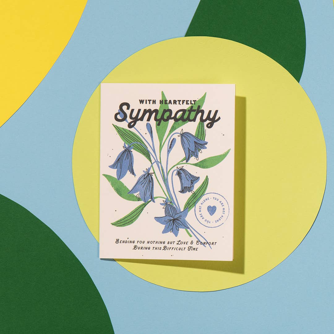 Sympathy card with floral design on a colorful geometric background