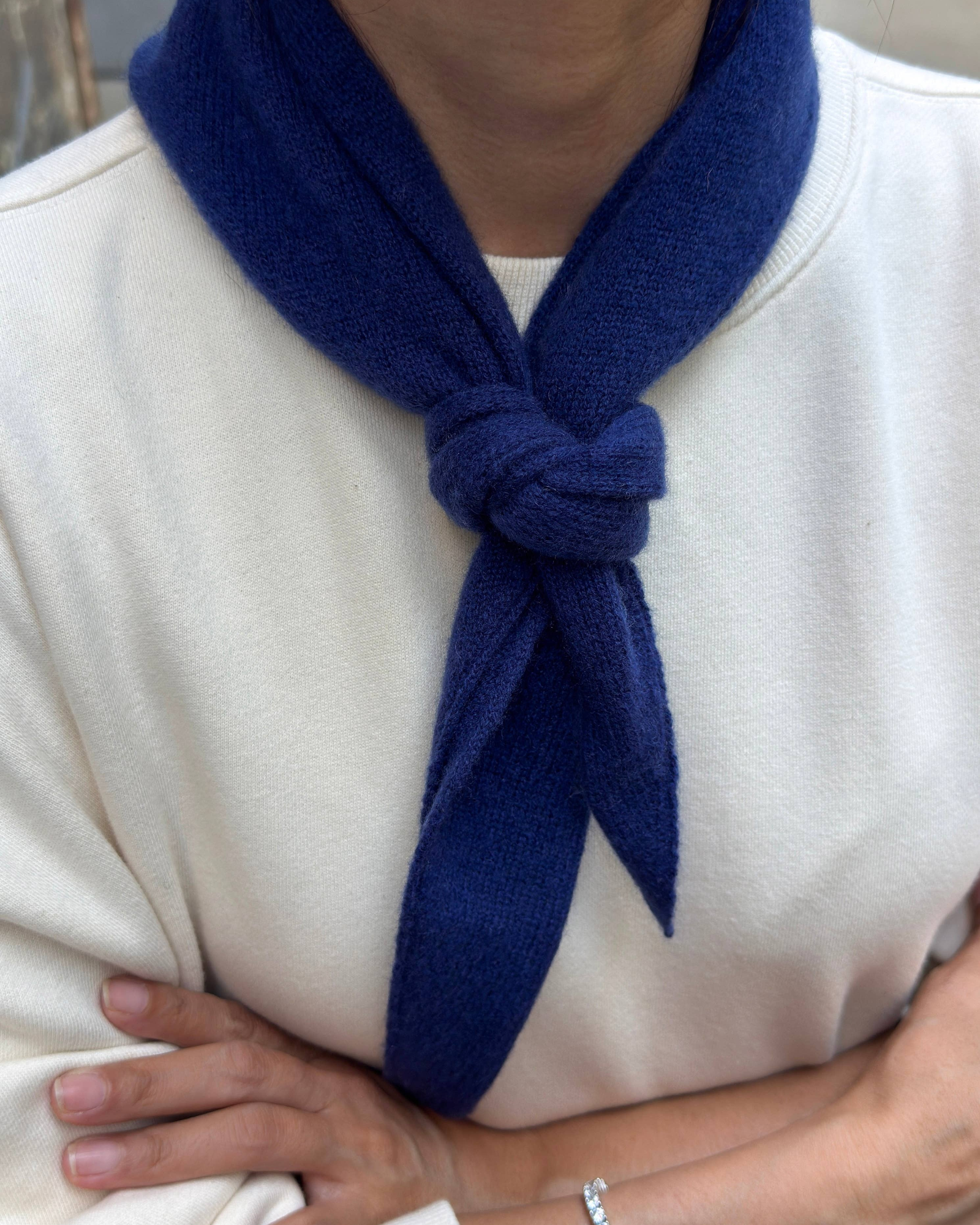 JONES + CO navy blue cashmere and wool blend bandana scarf tied in a simple knot around the neck