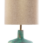 Table lamp with textured green base and beige fabric shade on a white background