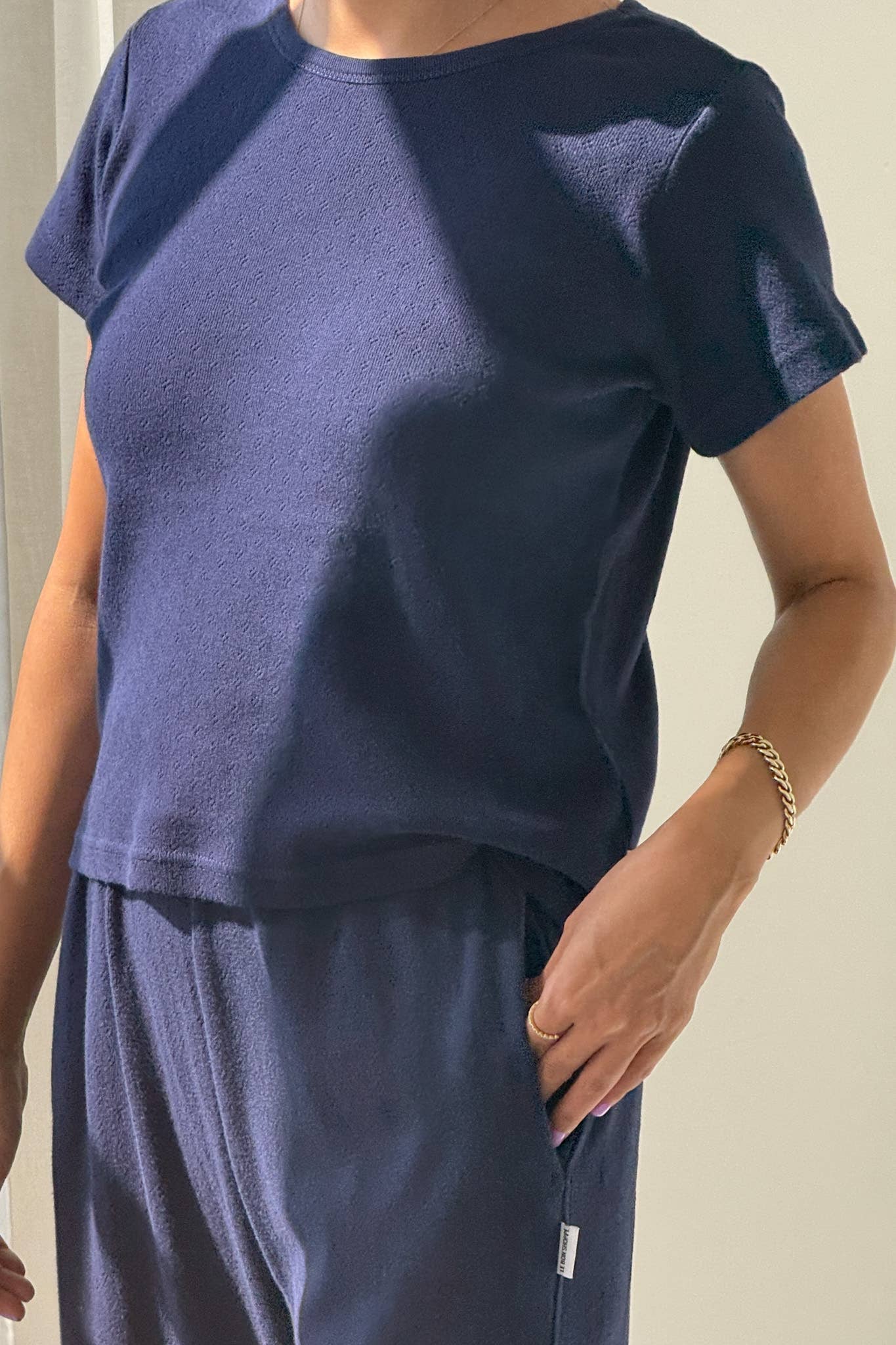 Person wearing a navy blue outfit with a plain background
