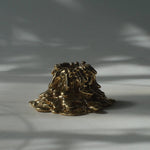 Gold decorative object on a gray surface with shadows