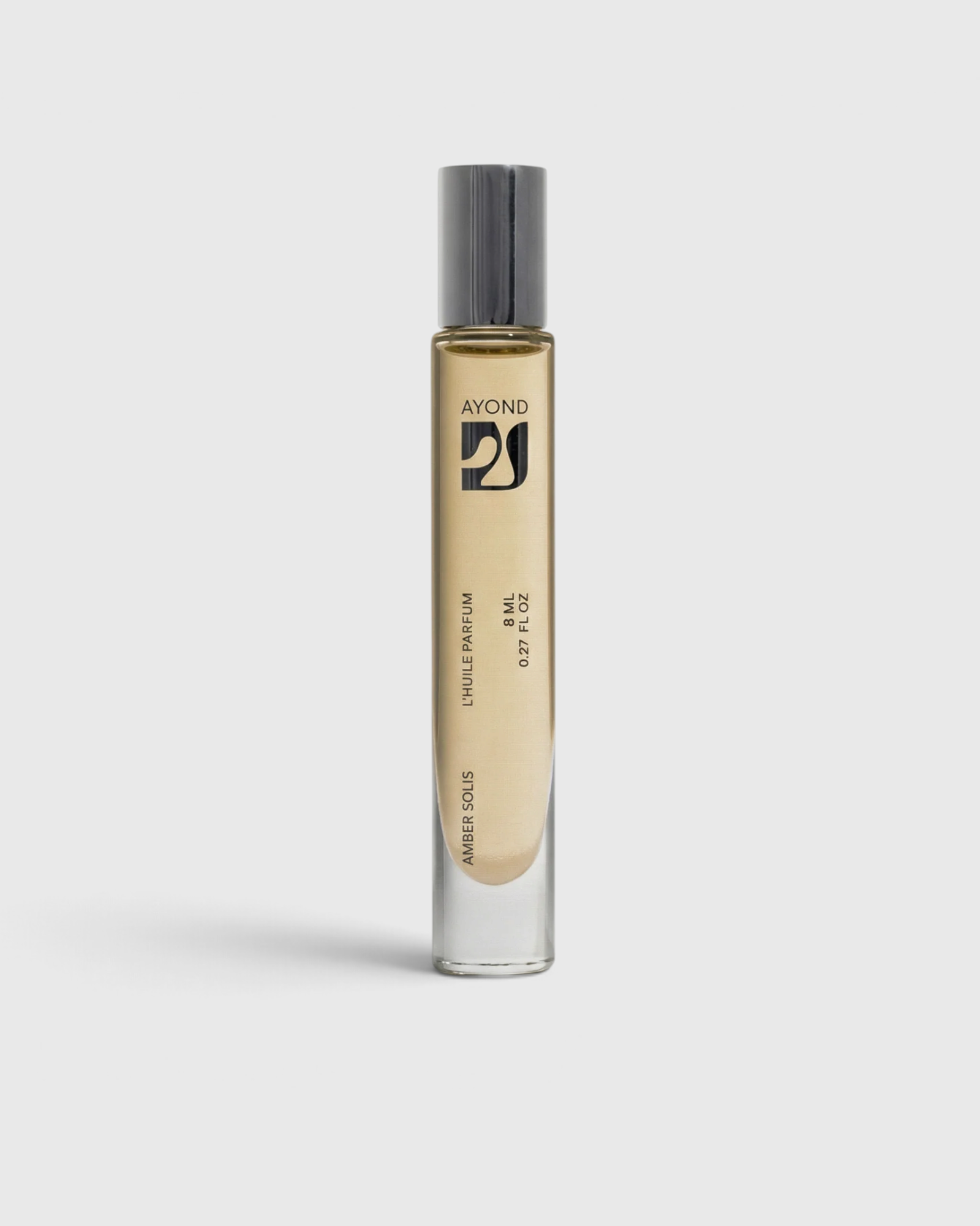 JONES + CO Amber Solis natural perfume oil roll-on in a sleek glass bottle with a metallic cap on a white background.