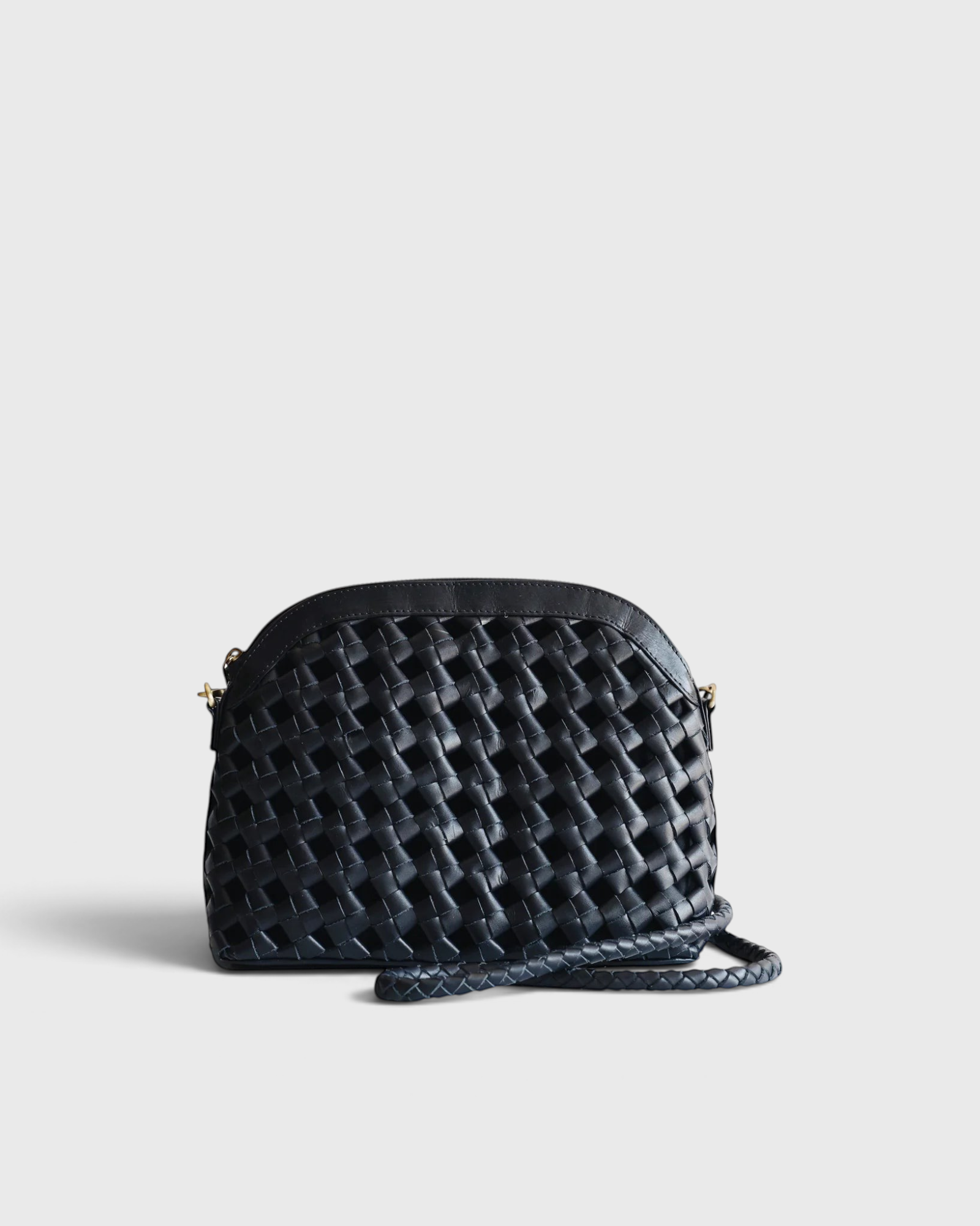 JONES + CO Carmen black handwoven leather shoulder bag with an arched silhouette and adjustable strap.