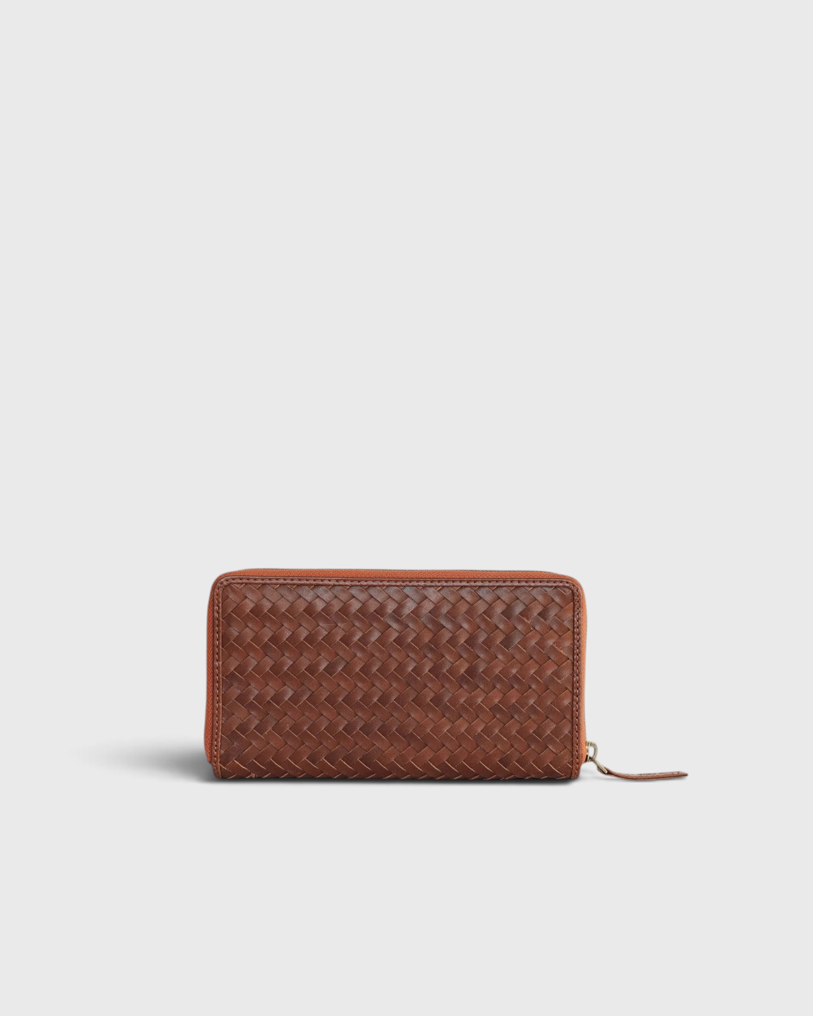 JONES + CO Luca wallet in sienna brown handwoven leather with a secure wrap-around zipper closure.