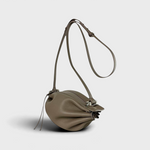 JONES + CO Bon-Bon taupe leather shoulder bag with pleated ends and a silver metal clasp on a light grey background