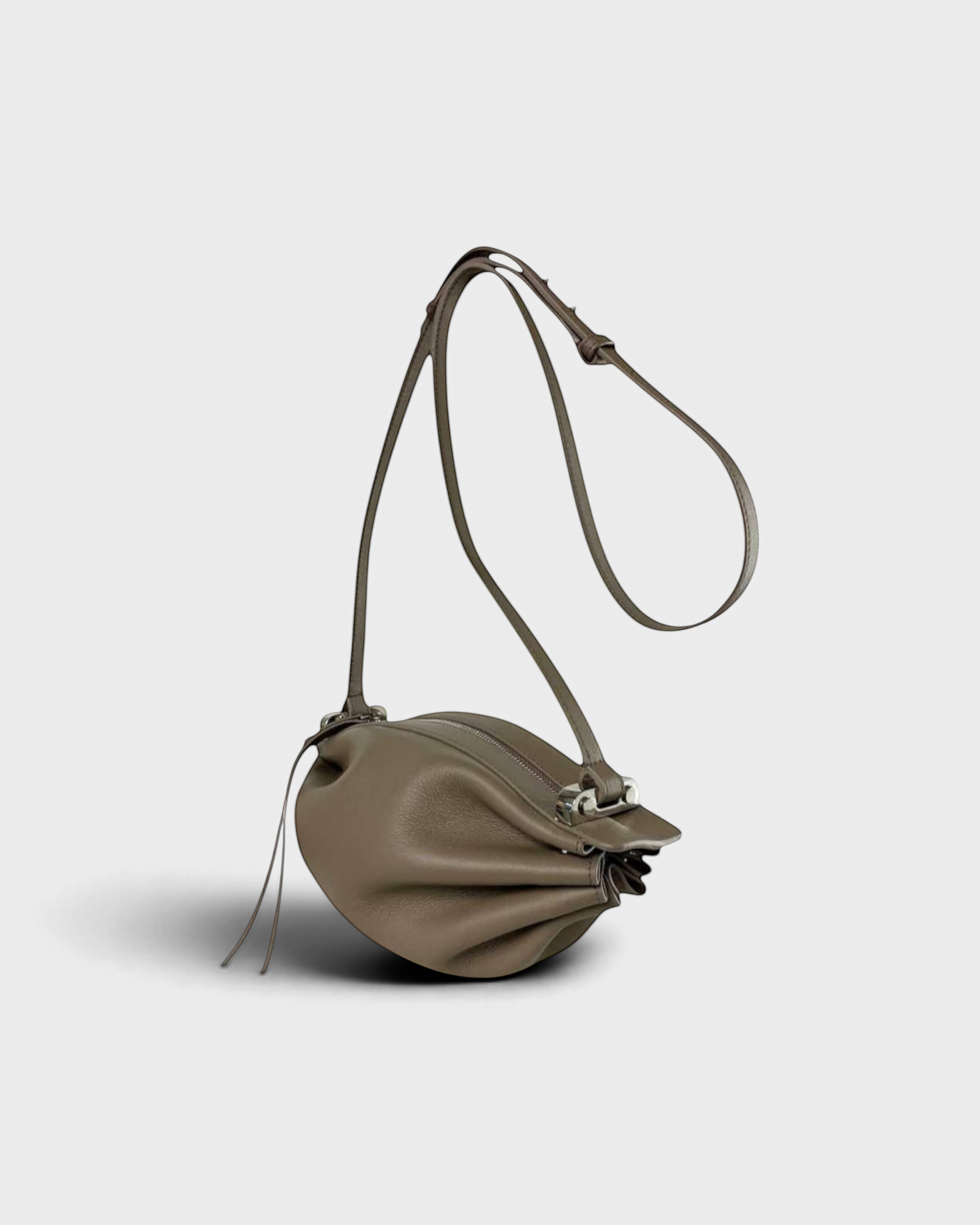 JONES + CO Bon-Bon taupe leather shoulder bag with pleated ends and a silver metal clasp on a light grey background