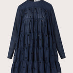 Merlette Soliman Dress in Navy — flat product shot of the tiered cotton voile dress with tonal floral embroidery, long sleeves and round neck
