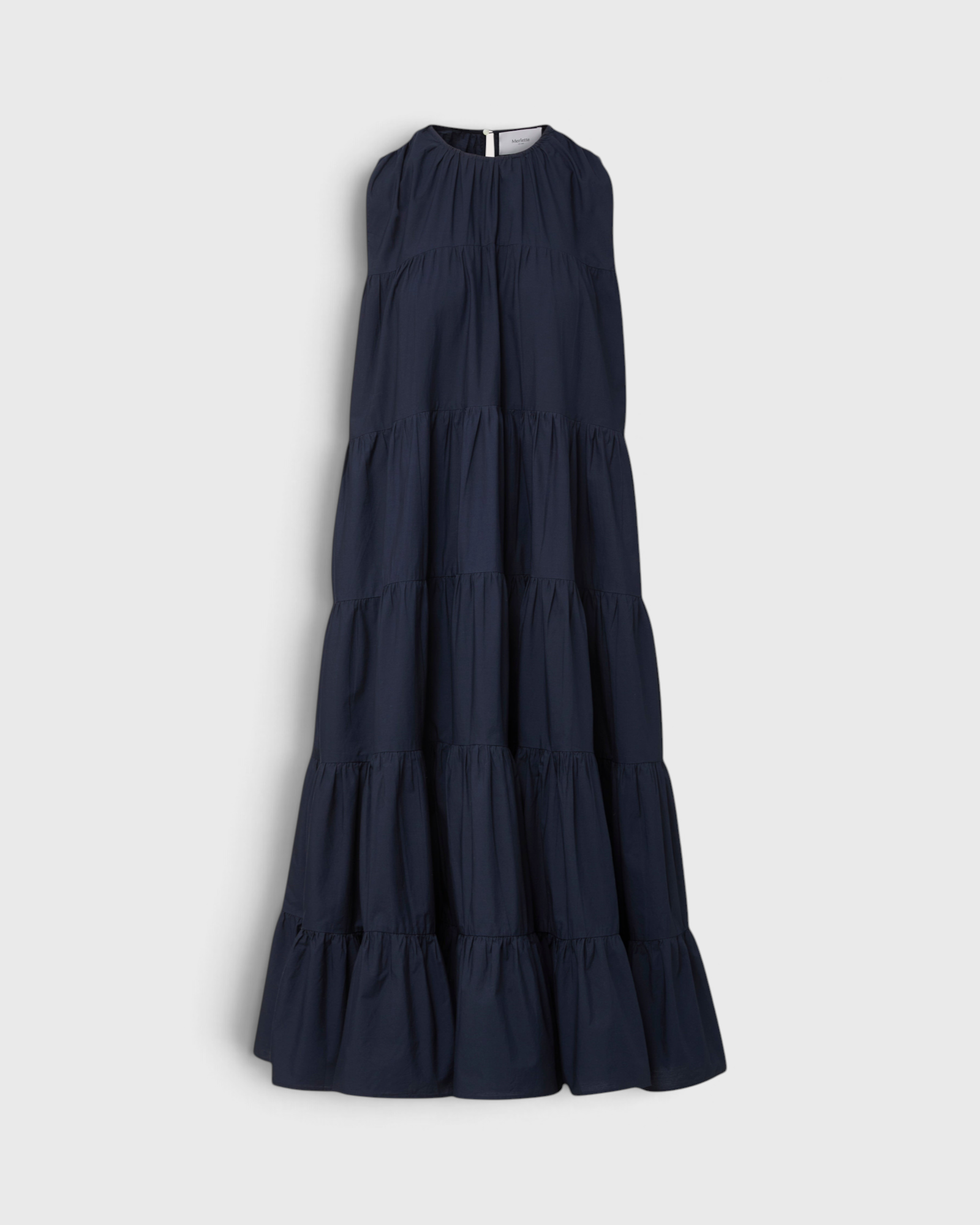 Merlette Caron Dress in Navy — flat product shot of the sleeveless tiered cotton poplin maxi with a gathered round neck and ruffled hem