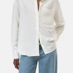 Person wearing a white button-up shirt and blue jeans on a white background