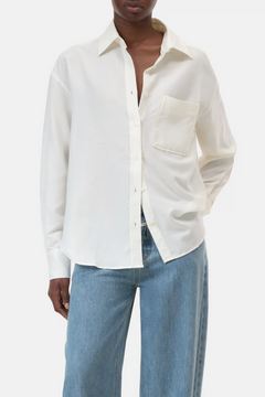 Person wearing a white button-up shirt and blue jeans on a white background