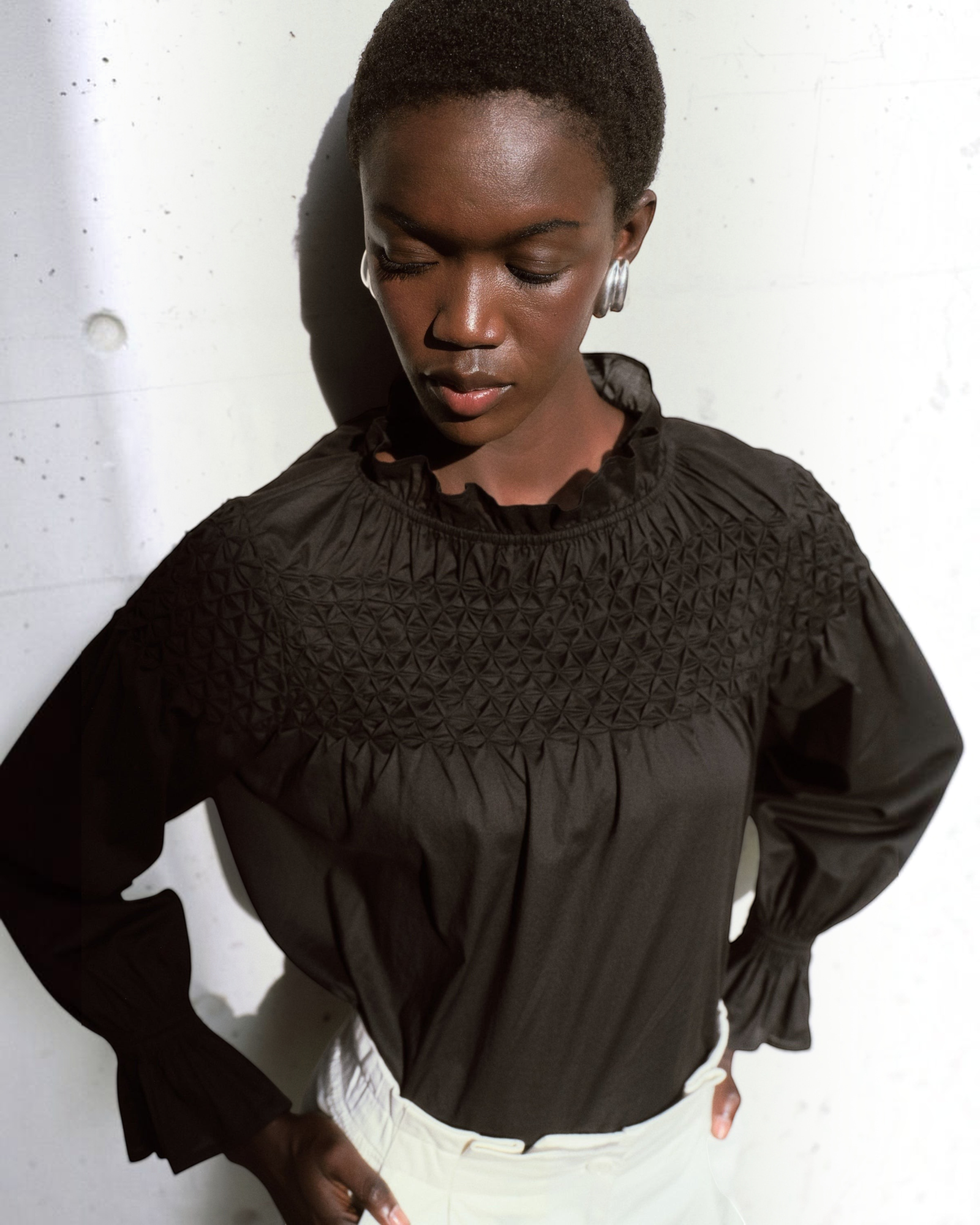 Merlette Majorelle Top in Black - campaign image showing the ruffled collar and smocking