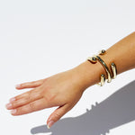 Hand wearing a gold bracelet on a white background
