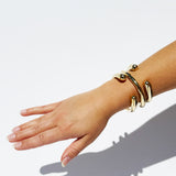 Hand wearing a gold bracelet on a white background