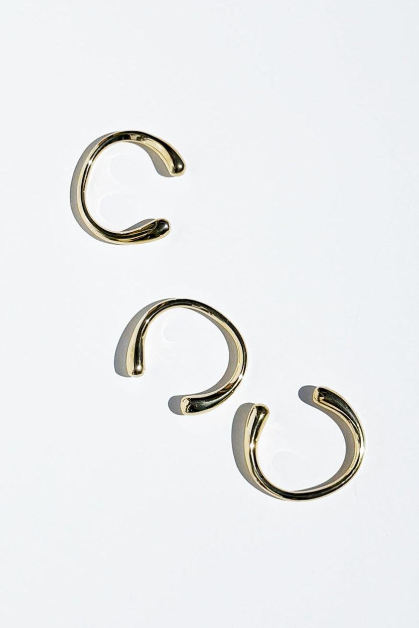 Three brass bangles on a white background