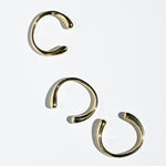 Three brass bangles on a white background
