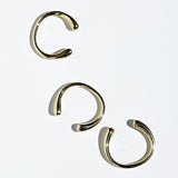 Three brass bangles on a white background