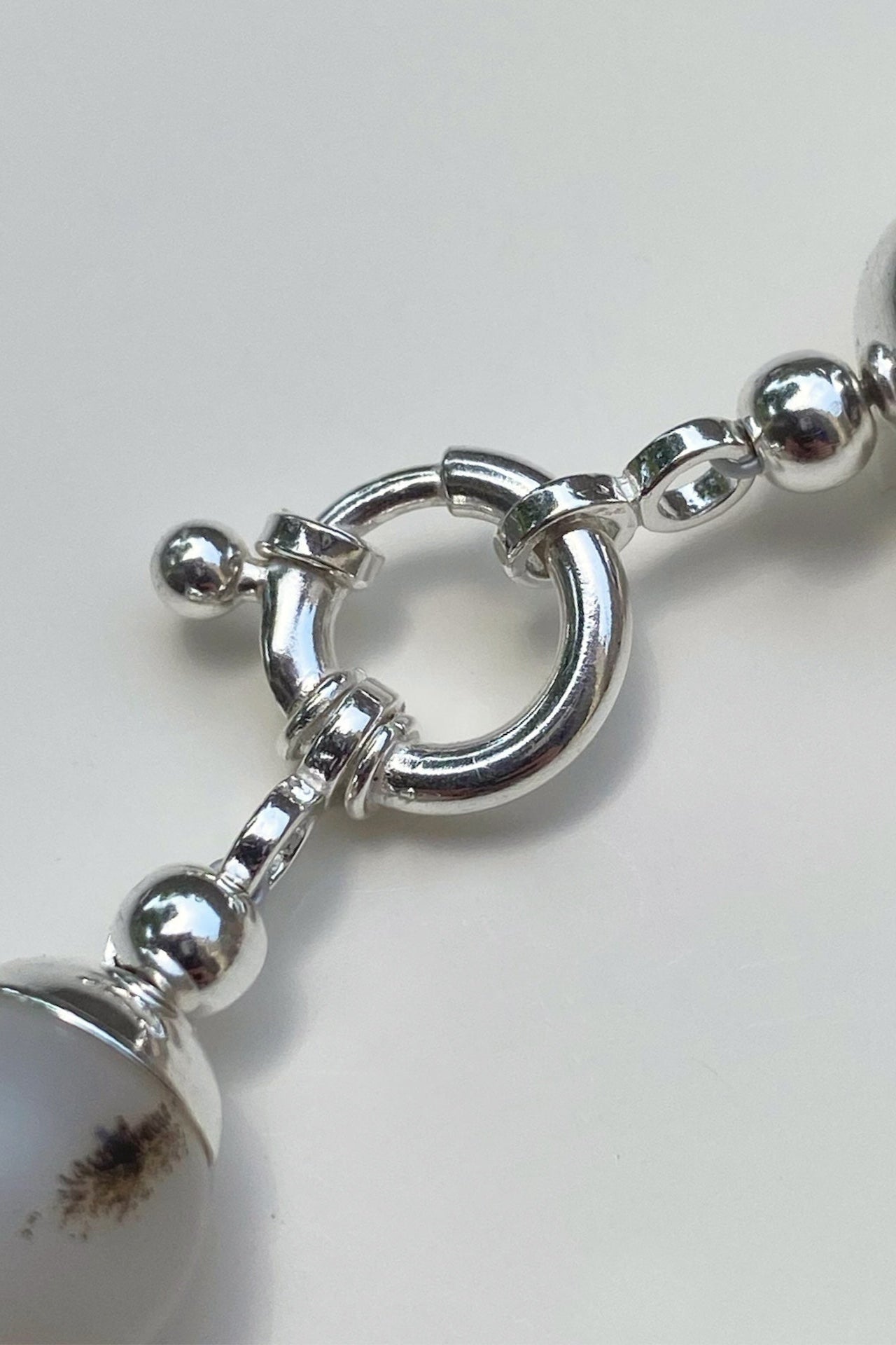Close-up of a silver bracelet with large beads on a white background
