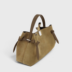 JONES + CO Gyoza pouch in fennel suede with brown leather handles and side knot details on a light grey background.