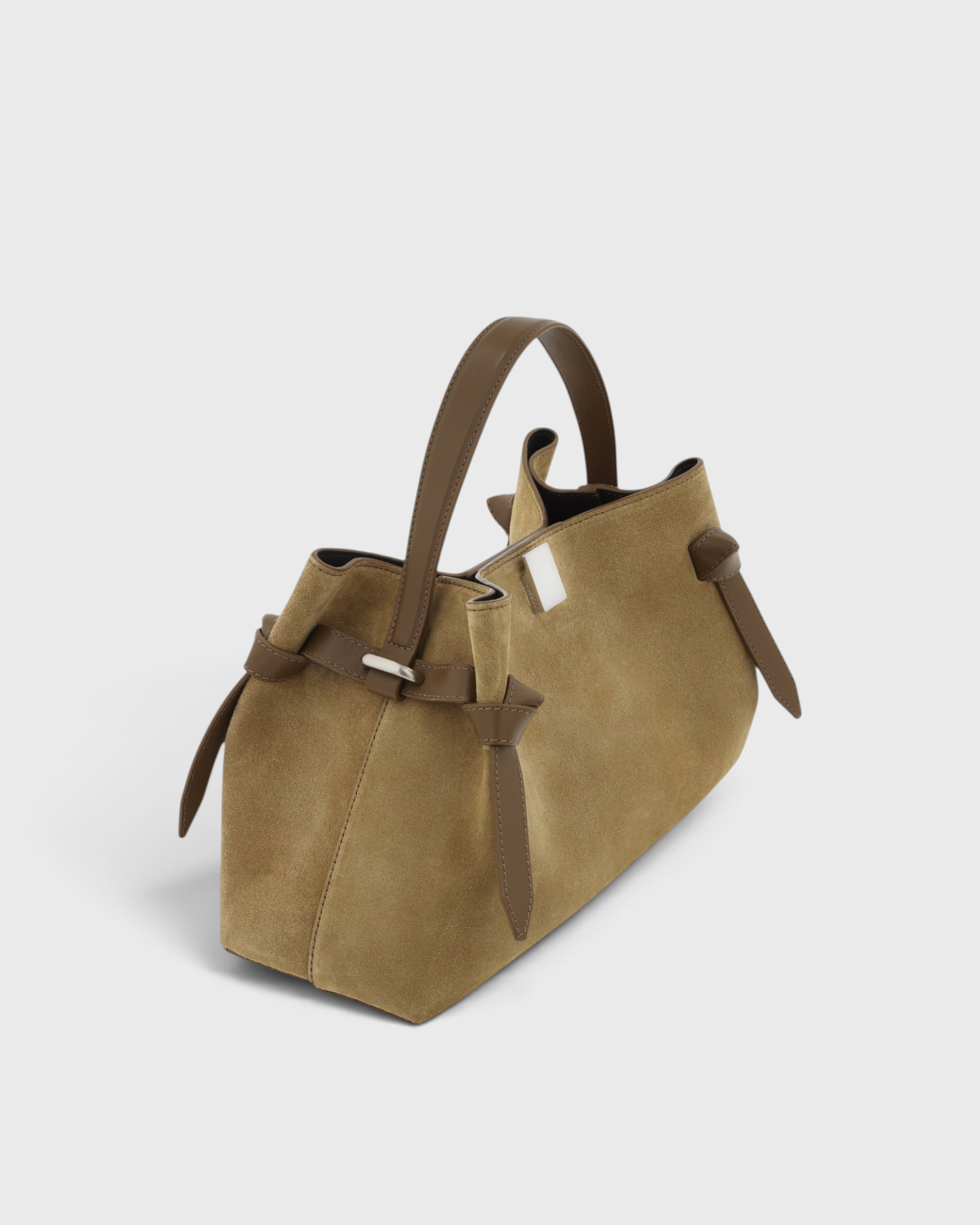 JONES + CO Gyoza pouch in fennel suede with brown leather handles and side knot details on a light grey background.