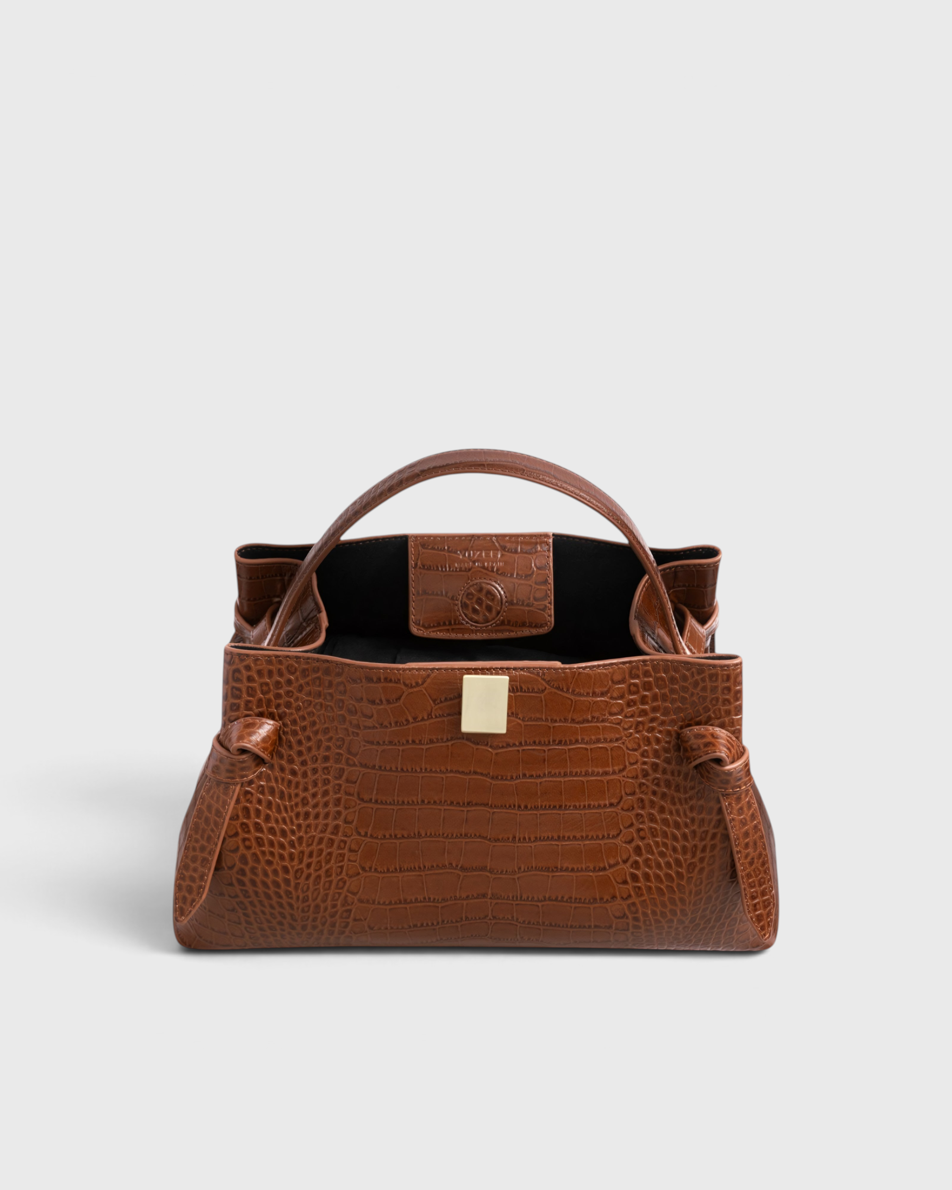 JONES + CO Gyoza pouch in brown Sierra embossed leather with a structured silhouette and gold-tone hardware.