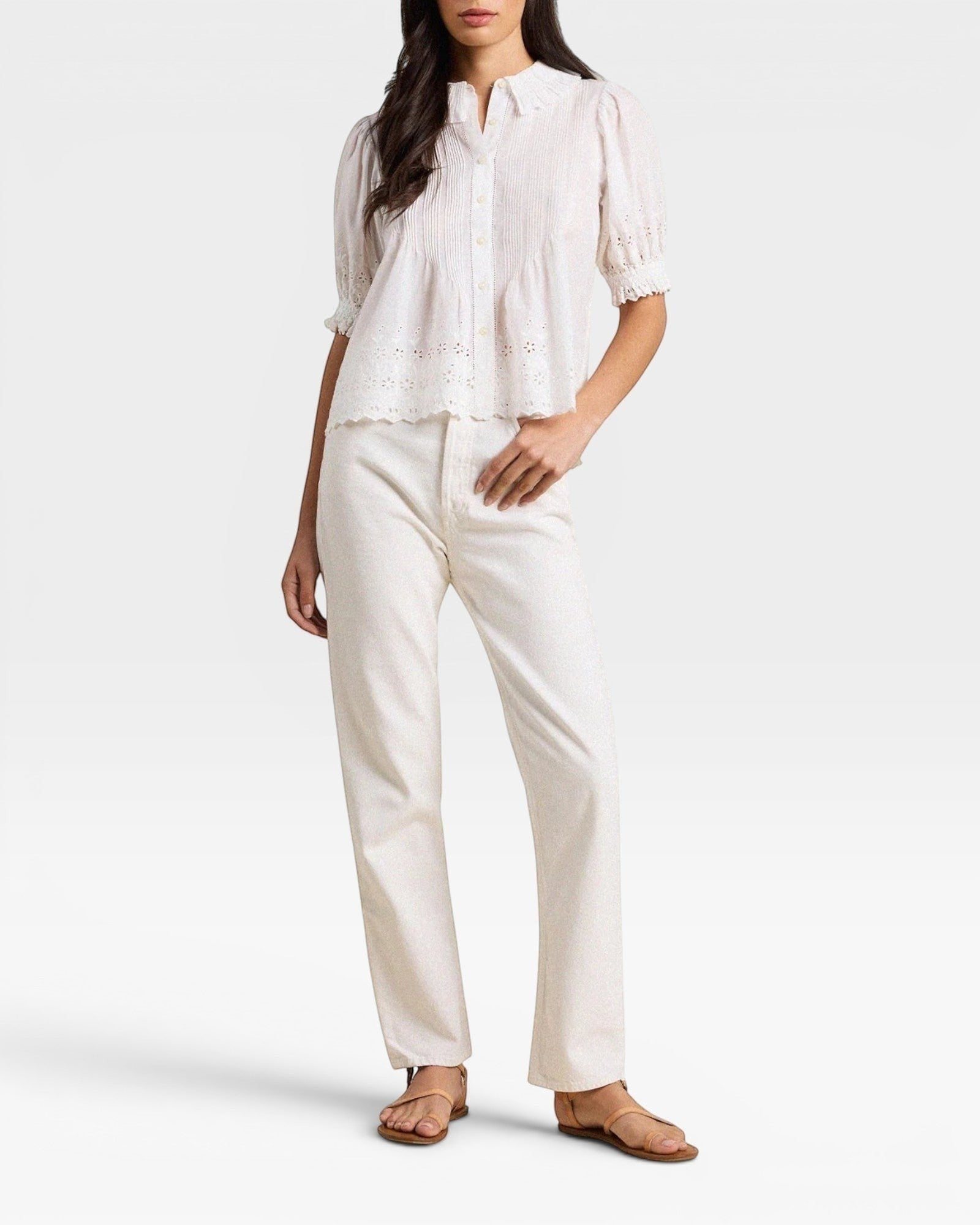 Woman wearing a white blouse and pants on a white background